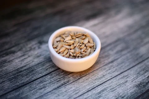Pale shelled sunflower seeds in a small bowl